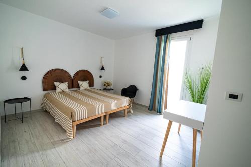 um quarto com uma cama e uma grande janela em Appartamento Sorso em Sorso