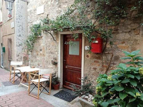 een deur van een gebouw met een tafel en stoelen buiten bij La Casa di Mezzo - The Middle House in Monte Marcello