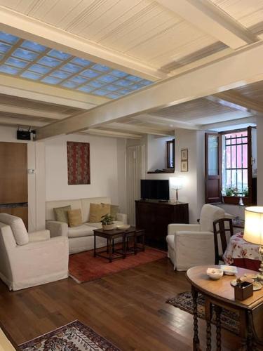 a living room with white couches and a table at La Casa di Mezzo - The Middle House in Monte Marcello