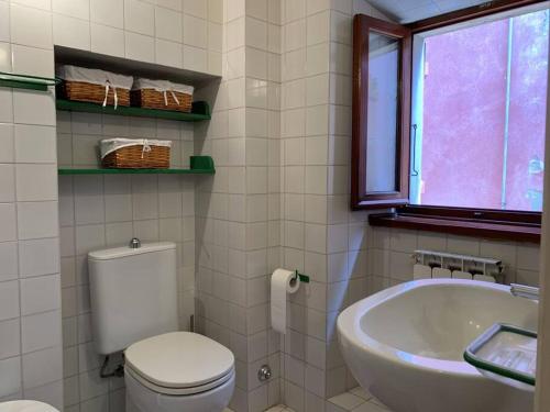 a bathroom with a toilet and a sink and a tub at La Casa di Mezzo - The Middle House in Monte Marcello