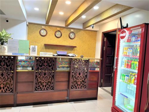 um balcão de caixa de loja com relógios na parede em DINH DINH 2 AIRPORT HOTEL em Ho Chi Minh
