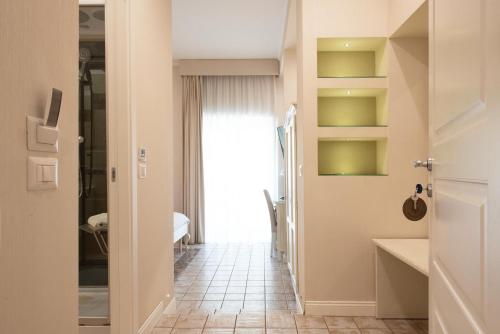 a bathroom with a hallway with green shelves at Certosa Suite in Naples