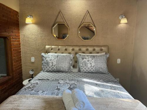 um quarto com uma cama grande com espelhos por cima em Chalé 08 com hidro no coração de Penedo em Itatiaia
