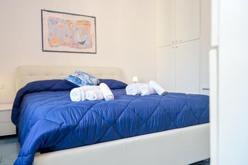 a bed with a blue comforter and three pillows at Armarì Panoramic Flat in Vietri