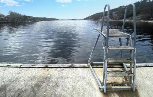 a chair sitting on the side of a boat in the water at Awesome Home In Grundsund With Wifi in Grundsund
