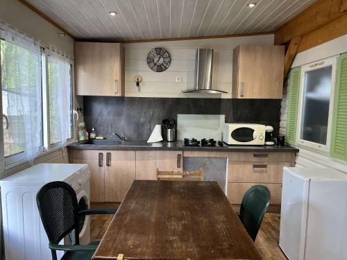 kuchnia ze stołem, krzesłami i kuchenką mikrofalową w obiekcie Mobil Home 4 personnes w mieście Nances