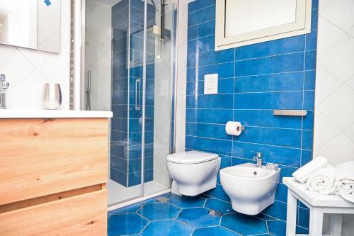 a blue bathroom with a toilet and a shower at Armarì Panoramic Flat in Vietri