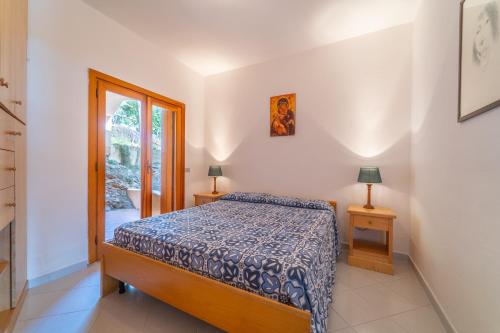 una camera con un letto, due lampade e una finestra di Punzy by DomusAway a Porto Istana