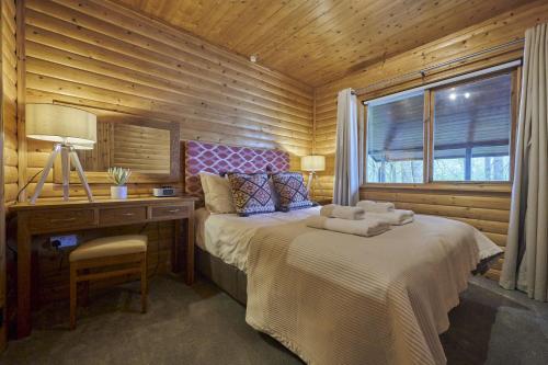 Un dormitorio con una cama y un escritorio y una ventana. en Heron Lodge with Hot-tub, en Carlisle