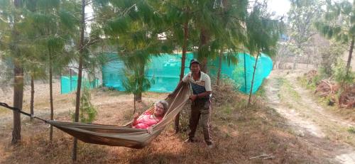 a man standing next to a woman in a hammock at Everest Home Stay Temal Kalimati Tower in Thapathali