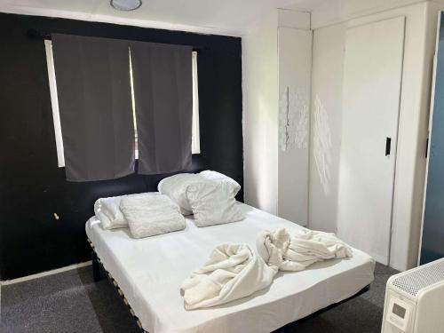 - une chambre avec un lit doté de draps et d'oreillers blancs dans l'établissement Mobil Home 4 / 6 personnes, à Nances