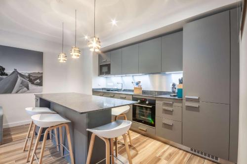 une cuisine avec un grand îlot et des tabourets de bar dans l'établissement Lapia 104 Superbe appartement 4 à 6 personne proche de toute commodité, à Morzine