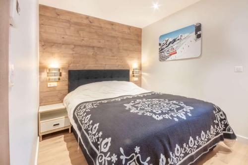 une chambre avec un lit et un mur en bois dans l'établissement Lapia 104 Superbe appartement 4 à 6 personne proche de toute commodité, à Morzine