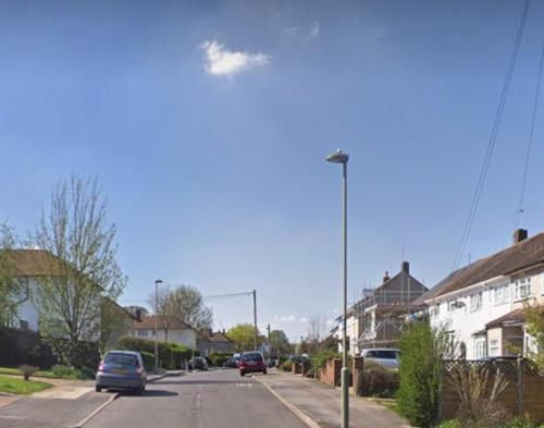a street with cars driving down a street with houses at Vienna Orpington in Orpington