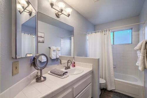 een badkamer met een wastafel, een spiegel en een bad bij Cozy Henderson Home - Near Vegas Strip & Nature in Las Vegas