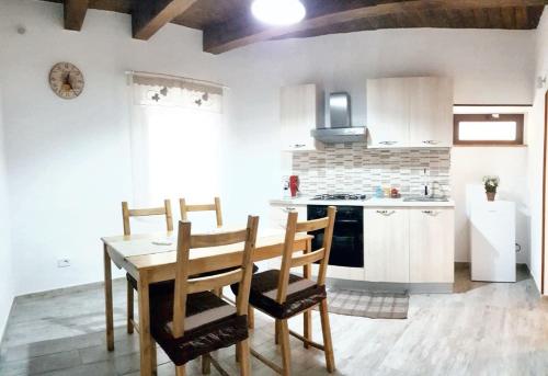 una cucina con tavolo e sedie in legno in una stanza di 3 bedrooms house with city view balcony and wifi at Frascineto a Frascineto