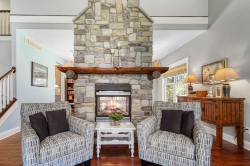 un soggiorno con 2 sedie e un camino in pietra di Fireside Retreat a South Haven