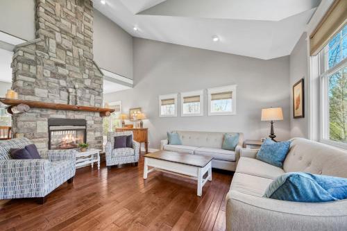 un soggiorno con divani e camino in pietra di Fireside Retreat a South Haven