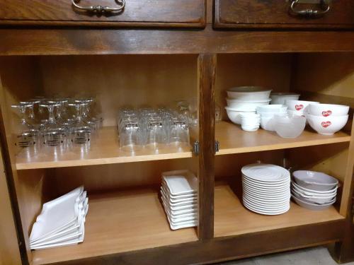 une armoire remplie de assiettes, de bols et de vaisselle dans l'établissement De Patuljak, à Houffalize