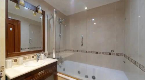y baño con bañera, lavabo y espejo. en Fabuloso Apartamento con vistas a la ria de Vigo, en Vigo