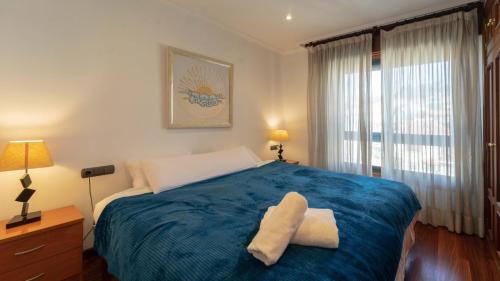 1 dormitorio con 1 cama grande con manta azul en Fabuloso Apartamento con vistas a la ria de Vigo, en Vigo