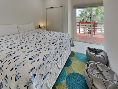a bedroom with a bed and a large window at Dock Of The Bay in Galveston