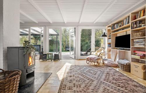 a living room with a fireplace and a tv at 3 Bedroom Awesome Home In Vejby in Vejby