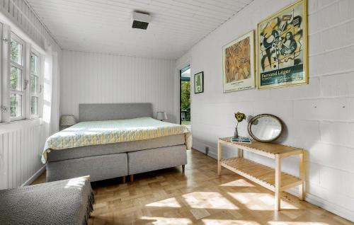 a bedroom with a bed and a mirror and a table at 3 Bedroom Awesome Home In Vejby in Vejby