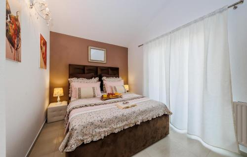 een slaapkamer met een groot bed en een groot raam bij Awesome Apartment In Kastel Stari With Kitchen in Kaštela