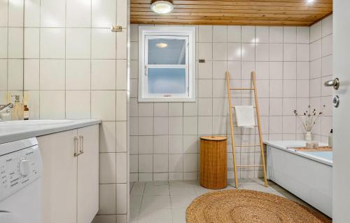 a white tiled bathroom with a window and a ladder at 4 Bedroom Pet Friendly Home In Strandby in Strandby