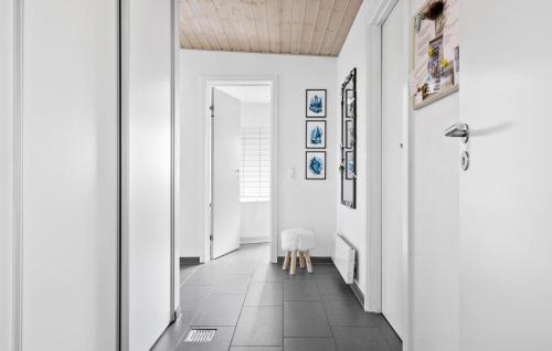 a hallway with white walls and a door and a stool at Amazing Home In Løgstør With Kitchen in Trend