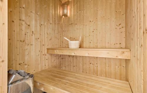a wooden sauna with a wooden shelf and a bucket at Amazing Home In Løgstør With Kitchen in Trend