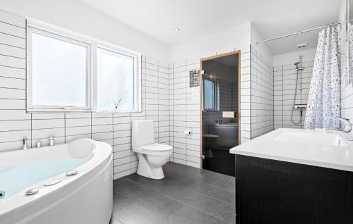 y baño con bañera, aseo y lavamanos. en Amazing Home In Lgstr With Kitchen, en Trend