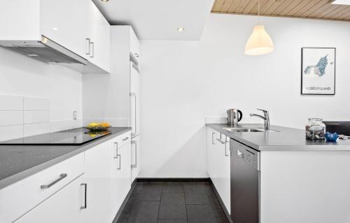 a white kitchen with white cabinets and a sink at Amazing Home In Løgstør With Kitchen in Trend