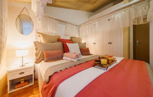 ein Schlafzimmer mit einem großen Bett mit bunten Kissen in der Unterkunft Cozy Apartment In Kastel Stari With Kitchen in Kaštela