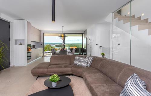 a living room with a brown couch and a kitchen at Villa Punat Hills With Pool 1 in Punat