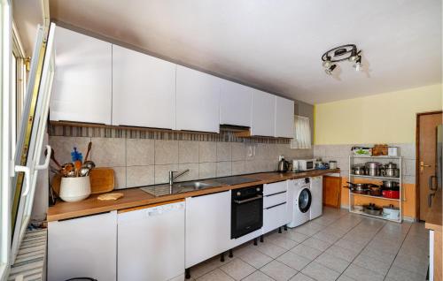 a kitchen with white cabinets and a washer and dryer at 4 Bedroom Lovely Apartment In Krusevo in Kruševo