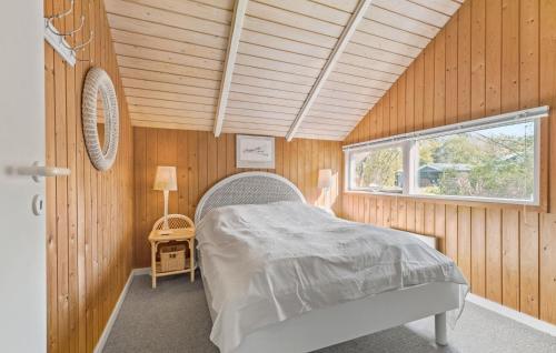 ティスヴィレライにあるNice Home In Tisvildeleje With Wifiの木製の部屋にベッド1台が備わるベッドルーム1室があります。