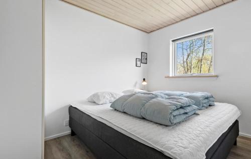 a bedroom with white walls and a bed with blue blankets at Beautiful Home In Ebeltoft With 4 Bedrooms, Wifi And Indoor Swimming Pool in Ebeltoft