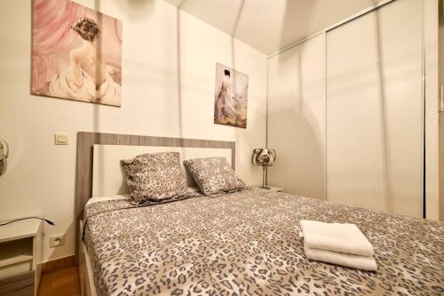 une chambre avec un lit et deux tableaux au mur dans l'établissement Beau 3 pièces avec jardinet et cour, 5 min plages, à Propriano