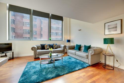 una sala de estar con 2 sofás y una alfombra azul en Crown Apartments 102 - By Week2Week, en Newcastle