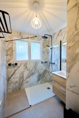 une salle de bain avec douche et lavabo dans l'établissement Beau 3 pièces avec jardinet et cour, 5 min plages, à Propriano