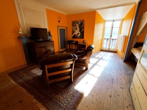 un soggiorno con pareti arancioni e TV di Chateau Montegut a Montégut