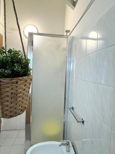 a bathroom with a shower with a toilet and a basket at Il gufo barocco in Noto