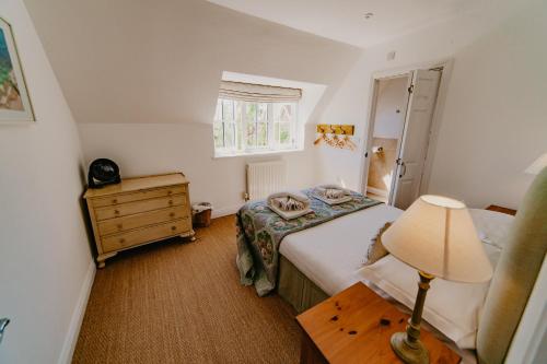 a small bedroom with a bed and a lamp at Dairyman's Cottage At Tapnell Farm in Yarmouth