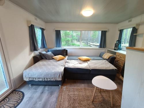 a bedroom with a bed and a couch and a table at Tinyhaus idyllisch am Waldesrand in Cottbus