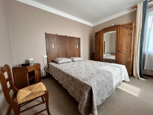 une chambre avec un lit, une chaise et un miroir dans l'établissement 762 - Maison bretonne à moins de 2 kms des Plages., à Erquy