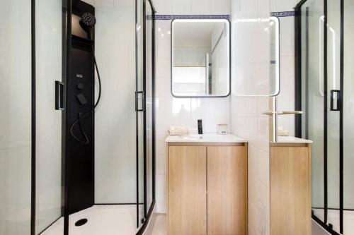 une salle de bain avec un lavabo et un miroir dans l'établissement Studio calme et élégant avec vue mer, à Cannes