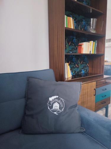a pillow sitting on a couch with a book shelf at Lawendowo- sauna, basen, domki w ogrodzie i apartamenty w kamienicy in Sandomierz