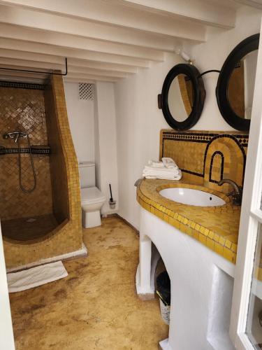 a bathroom with a sink and a shower and a toilet at Dar Adul in Essaouira